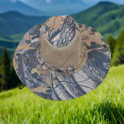 Camouflage-patterned sun hat with mesh back on a grassy background