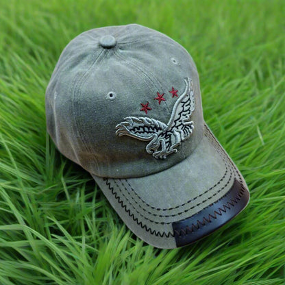A green nylon cap with an embroidered eagle and stars design on the front and a leather accent on the brim.