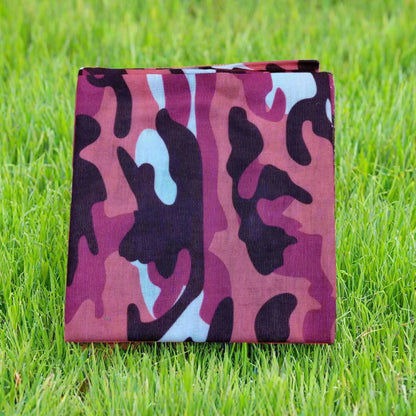 Pink and black camouflage blanket on grass