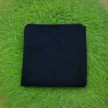 Folded black fabric on a beige background