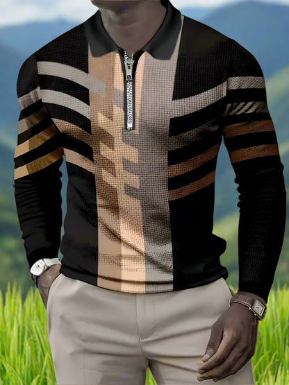 A man wearing a long sleeve gold and black striped shirt with a crew neckline, paired with beige trousers.