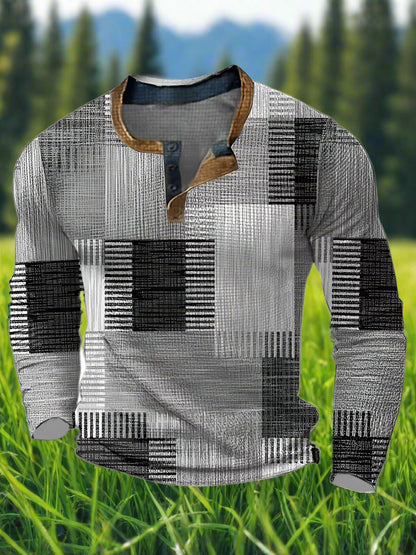 A long sleeve men's shirt with a geometric block print pattern in shades of grey and a button-up collar.