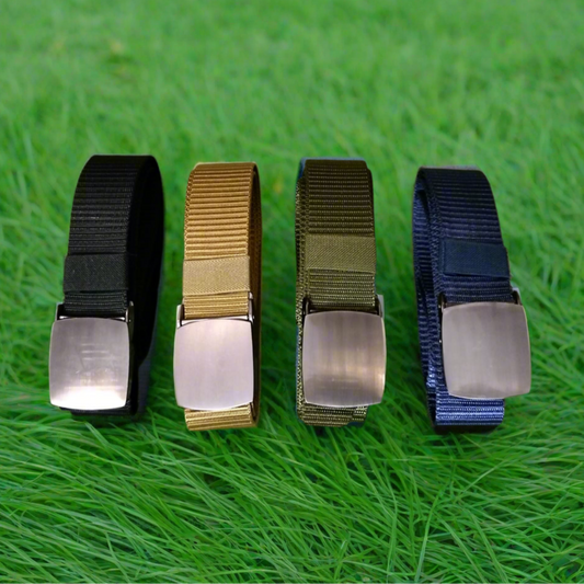Four belts in black, khaki, green, and blue on a grass background