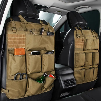 A beige car seat back storage bag attached to the back of a car seat, containing various items such as bottles and pouches.