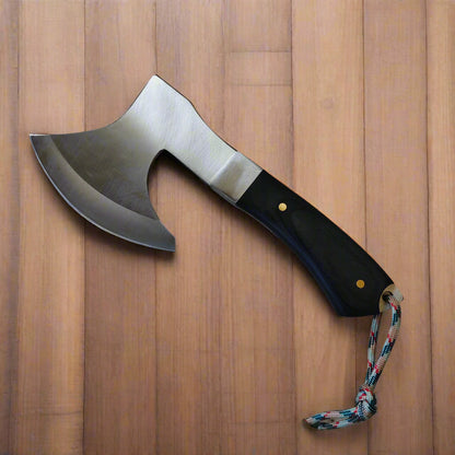 Axe with a black handle and colorful cord on a beige background