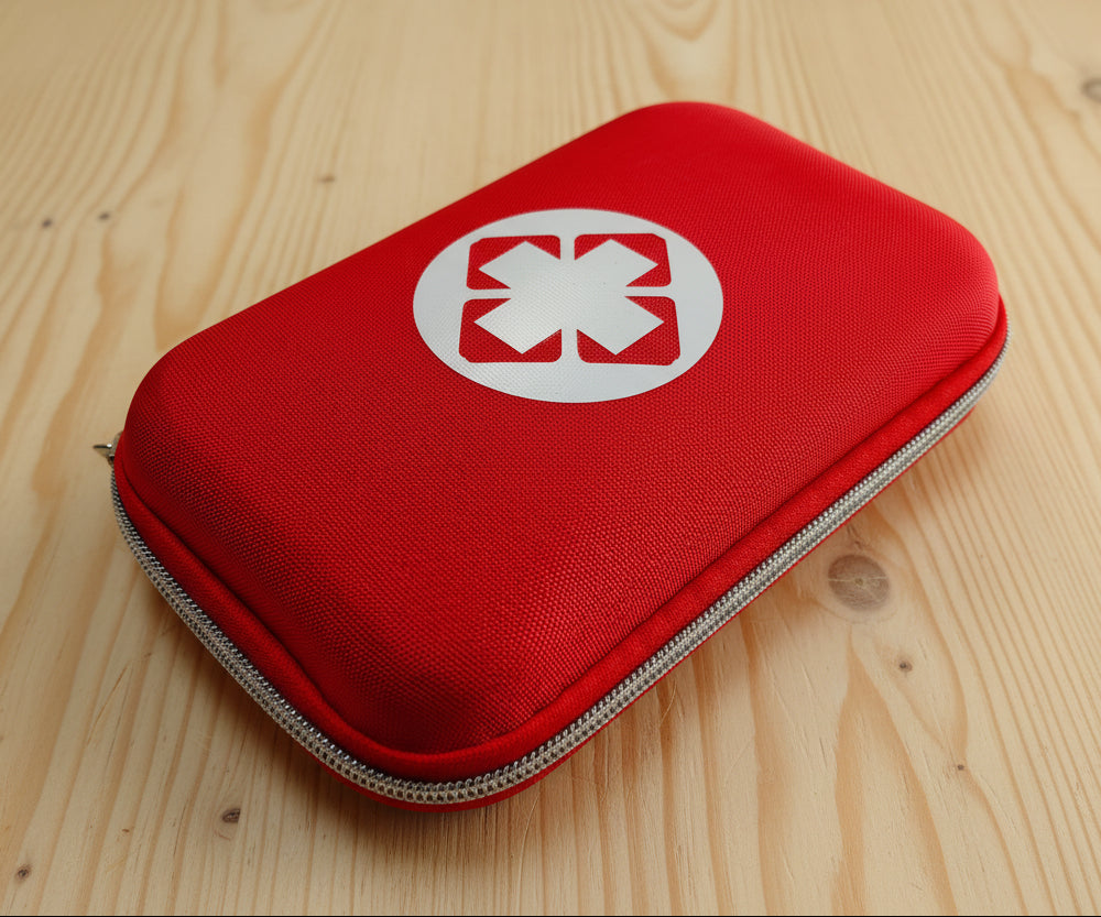 Red first aid kit with a white star of life symbol on a wooden surface
