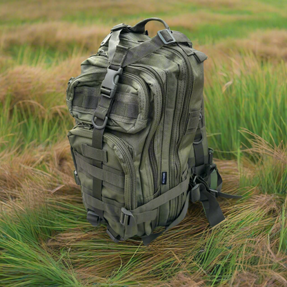 Green tactical backpack in a grassy field