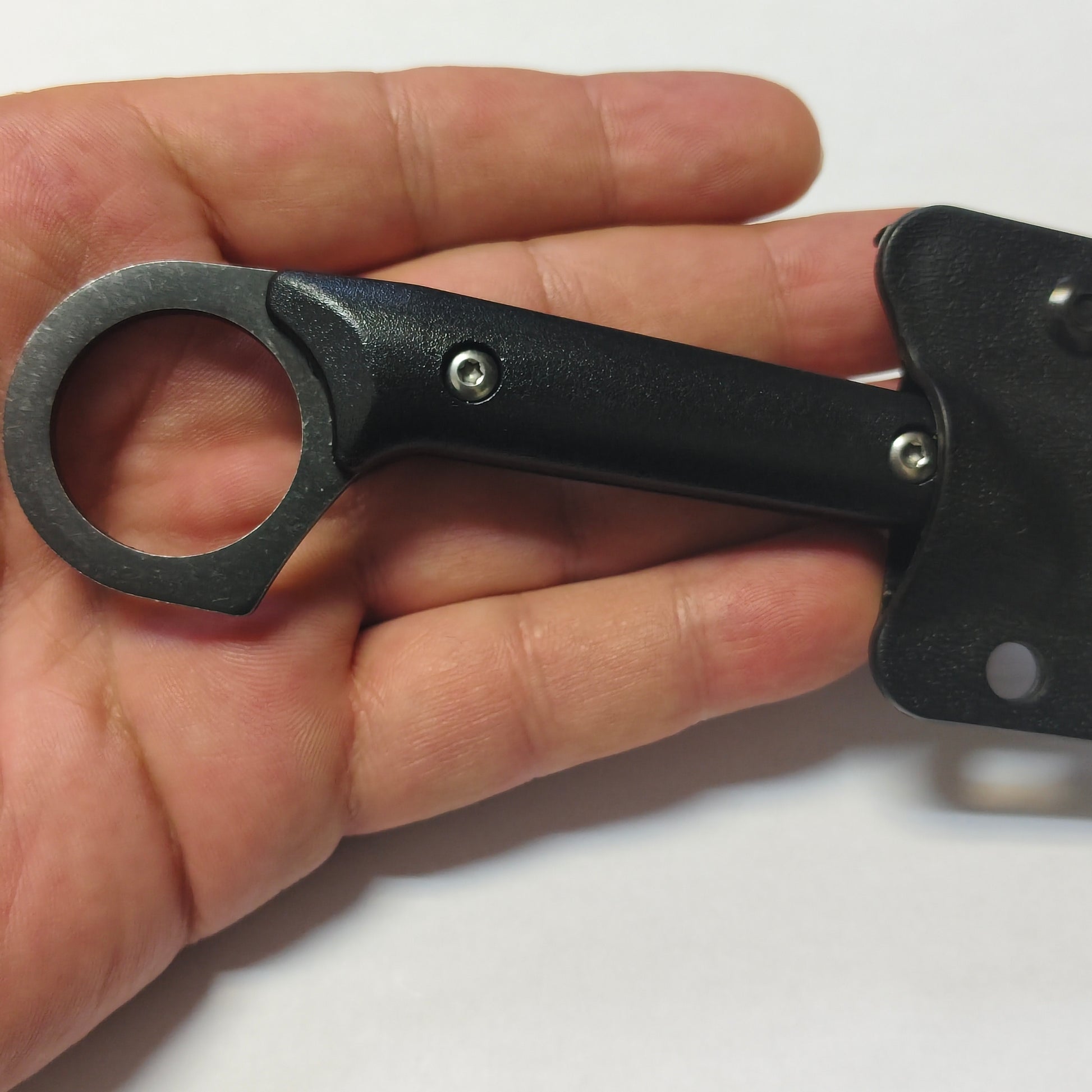 Hand holding a black tool with a white background