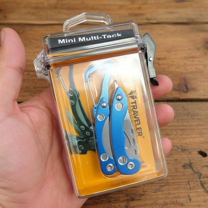 Hand holding a Mini Multi-Tack tool set packaging on a wooden surface