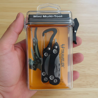 Mini multi-tool in packaging held by a hand with blurred tool background