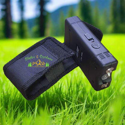 Black handheld device with a strap and 'Blades & Outdoors' logo on a textured beige background