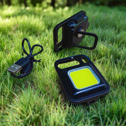 Black portable light with USB cable on grass