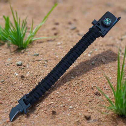 Black paracord survival bracelet with knife and compass on a beige background